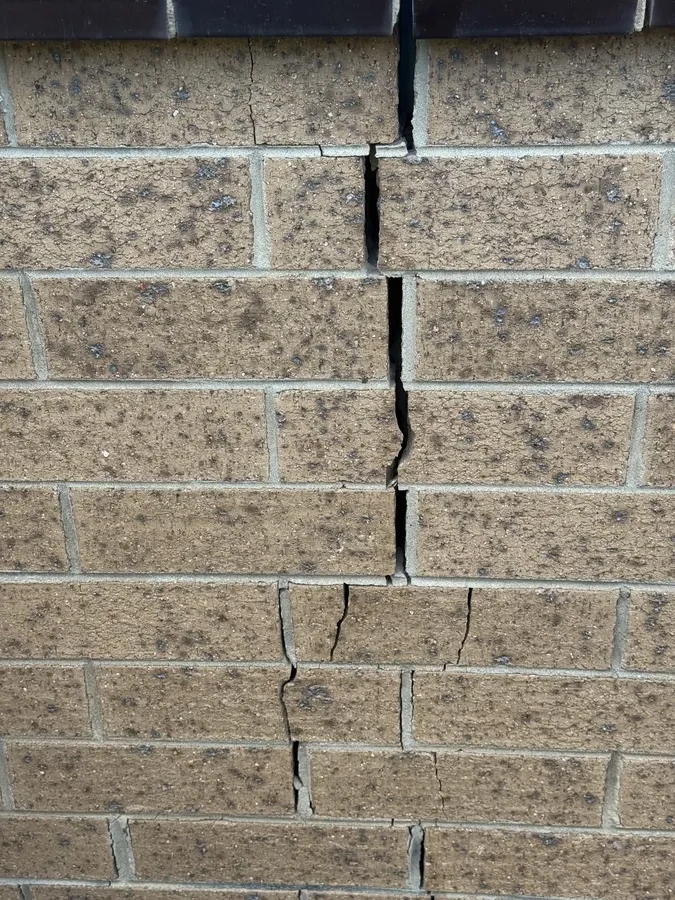 Diagonal step crack in an exterior brick wall